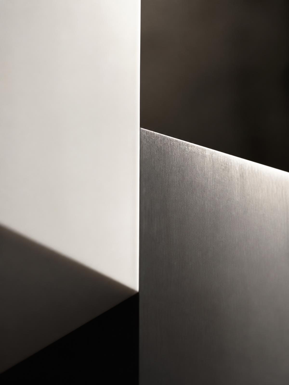 Raking light across a surgical-clean composite and steel edge. The moment of making.