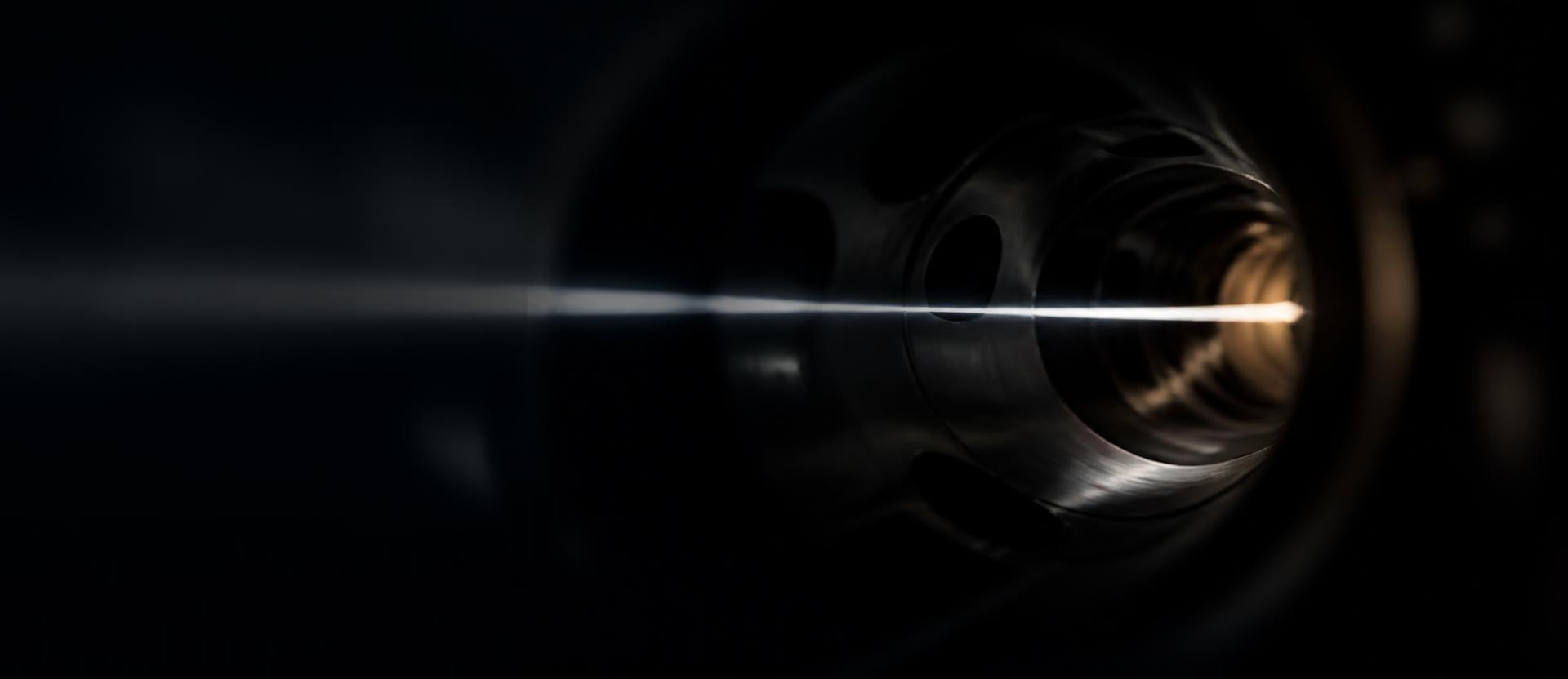 A thread of clinical light tracing through the dark interior of a precision instrument. Intelligence as a layer underneath everything.